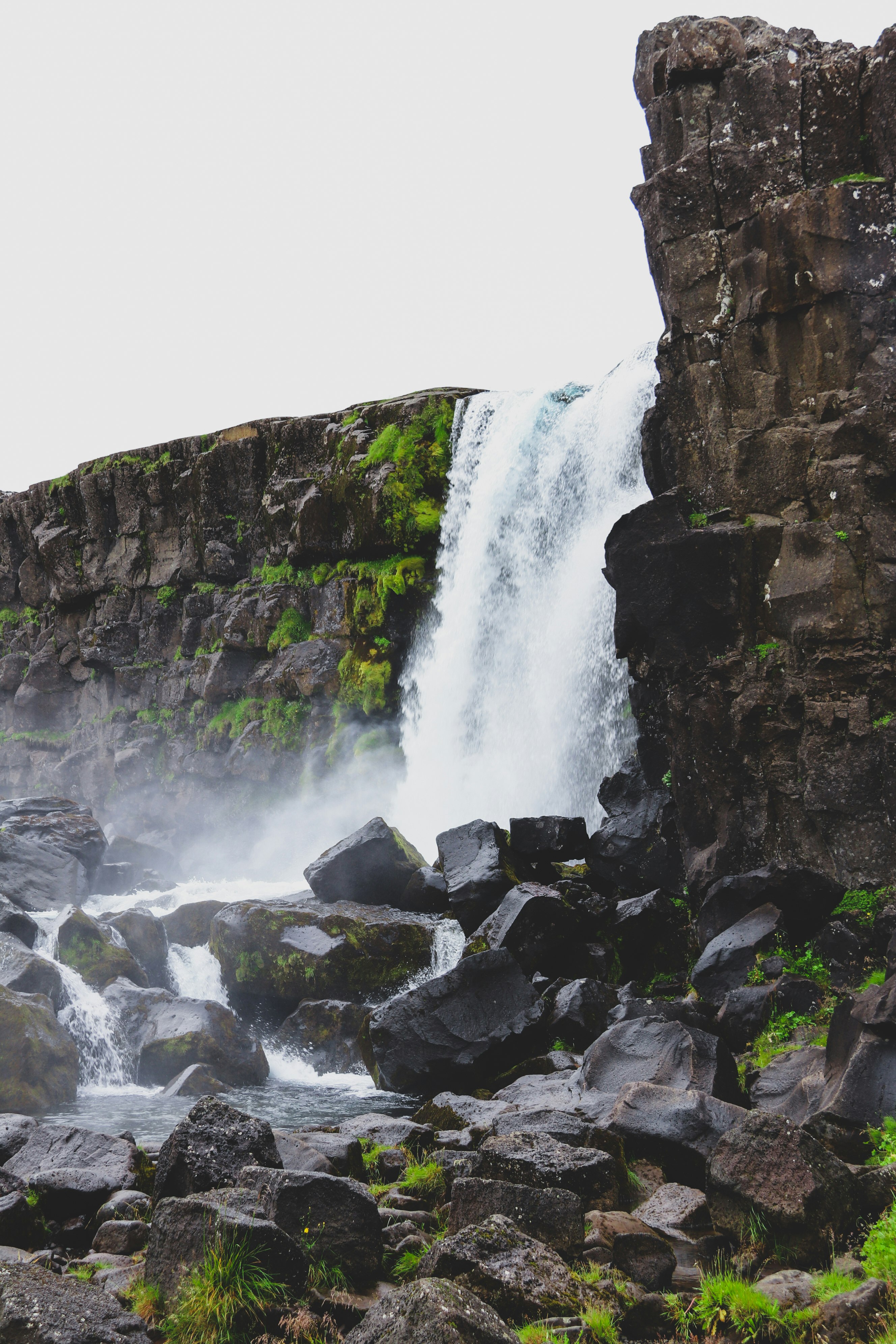 water falls on rocky mountain during daytime